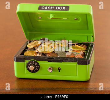 Green cash box with gold and silver coins Stock Photo