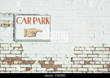 Hand pointing car park sign on an old painted wall Stock Photo