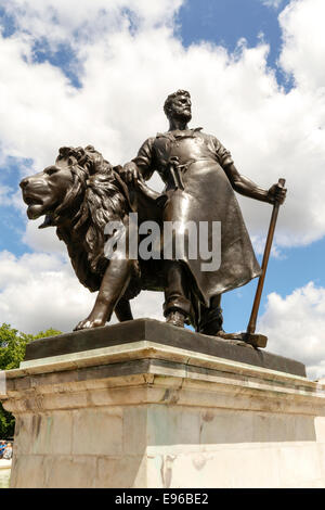 Bronze statue of man with lion, part of Queen Victoria Memorial outside Buckingham Palace, London Stock Photo