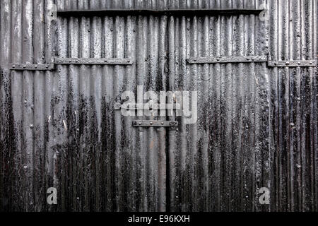 A corrugated tar black industrial door background. Stock Photo