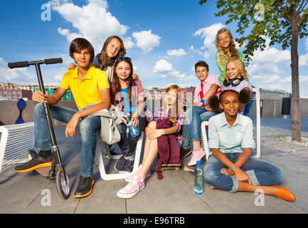International kids sitting on chairs with scooter Stock Photo