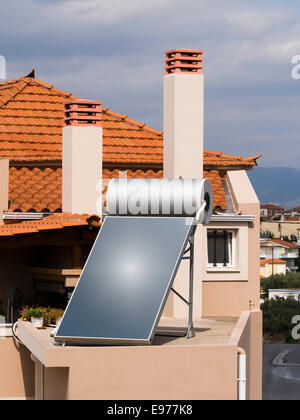 Solar water heater on roof of tile roofed house Stock Photo