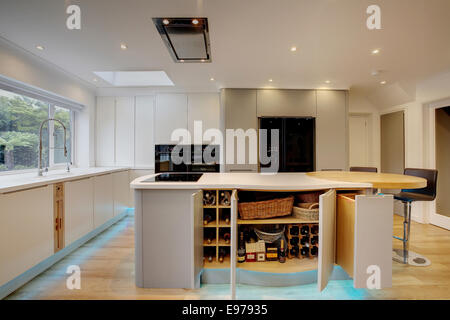 A modern kitchen inside a home in the UK with the doors open on the breakfast island. Stock Photo