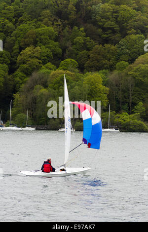 Small sailing dinghy with spinnaker sail on Lake Windermere in the English Lake District Stock Photo