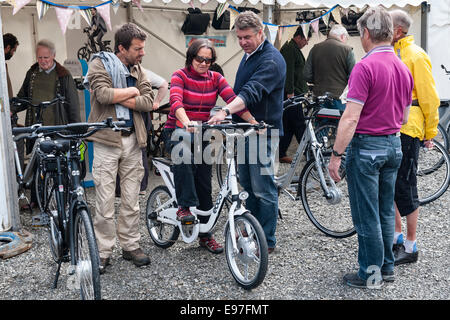 Presteigne, Powys, UK. Interested visitors trying out electric bikes at a trade show Stock Photo