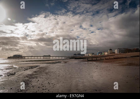 Worthing seafront and the pier viewed from the beach at low tide. Stock Photo