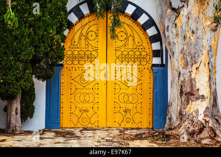 A typical yellow, studded wooden door in Sidi Bou Said, Tunisia. Stock Photo