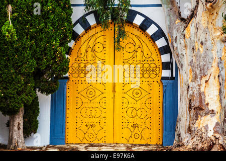 A typical yellow, studded wooden door in Sidi Bou Said, Tunisia. Stock Photo