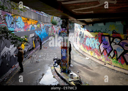 Graffiti artists decorating a wall in Leake Street in Waterloo. Stock Photo
