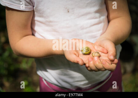 Little girl holding garden snails in hands Stock Photo