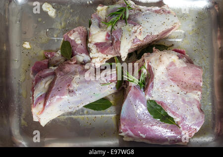 Raw leg of lamb, cut into pieces, stuffed with rosemary and bay and rubbed with oil and lemon for Turkish kuzu tandir Stock Photo