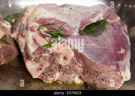 Raw leg of lamb, cut into pieces, stuffed with rosemary and bay and rubbed with oil and lemon for Turkish kuzu tandir Stock Photo