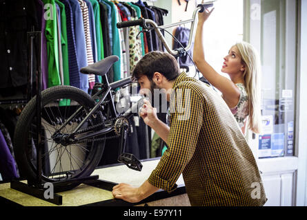 Young couple in bicycle shop looking at bike Stock Photo