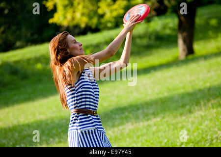 Young woman playing frisbee outdoors Stock Photo