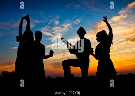 Young people dancing and having fun at sunset Stock Photo