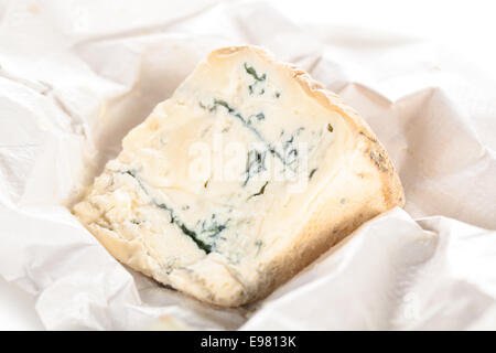 Fresh Italian gorgonzola on white crumpled paper. Stock Photo