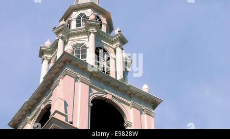 Older classic architecture close-up steeple much architectural detail. Building is all white against blue sky soft clouds. Stock Photo