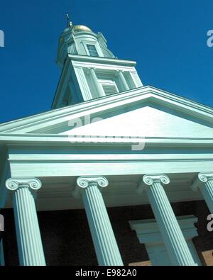 Older classic architecture decorative steeple Greek style columns soaring into sky as photographed from below. Building is all Stock Photo