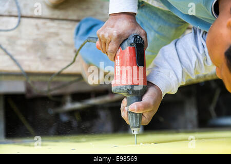 Worker installing wall system materials and insulation over frame of residential home. Los Angeles, California, USA Stock Photo