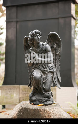 Black praying angel statue, monument on grave Stock Photo
