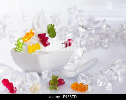 Cold Frozen yogurt Dessert served with ice cubes and brightly gummi bears Stock Photo