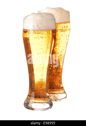 Two tall elegant pint glasses filled with pale translucent golden beer or ale with a good head of froth isolated on white Stock Photo