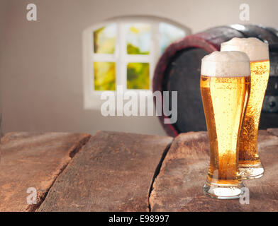 Closeup of two glasses of tasty fresh beer on a wooden table Stock Photo