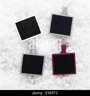 Four empty retro instant photo frames on snow for your collection of Christmas or seasonal images or messages Stock Photo