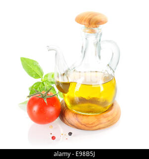 Olive oil cruet with basil leafs, fresh tomato and pepper grains Stock Photo