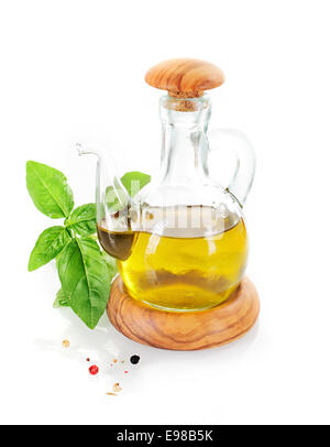 Olive oil cruet with basil leafs and pepper grains Stock Photo