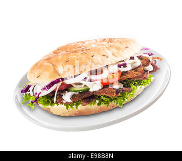Freshly prepared healthy doner or kebab with mixed salad ingredients and meat in a soft bun served on a plate for a quick meal or snack over a white background Stock Photo