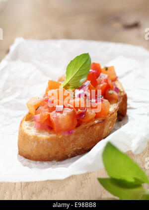 Delicious Italian bruschetta, an antipasti where a variety of toppings are put on toasted or grilled bread, in this instance a mixture of chopped tomato, onion, oil and seasonings on toasted baguette Stock Photo