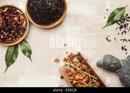 Close-up of medicinal and aromatic plants, leaves and an Asian ancient statue, symbol of traditional Chinese medicine Stock Photo