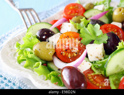 Delicious Greek salad with feta cheese, olives, tomato, cucumber and crispy lettuce garnished with chopped parsley