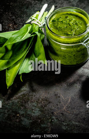 Jar of fresh home made pesto made with Bear Leek herbs, also known as wild garlic and a relative of chives, for a delicious savory sauce for Italian pasta Stock Photo
