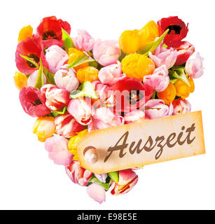 Relaxing heart-shaped greeting with an arrangement of beautiful mulitcoloured fresh tulips isolated on white with a gift tag reading - Best Mom - german called Auszeit Stock Photo