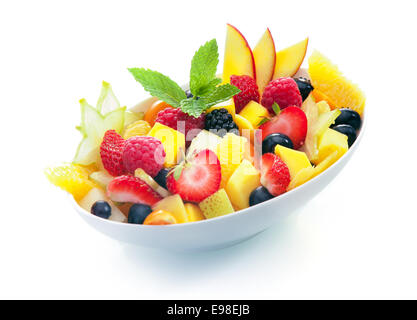 Bowl of colourful exotic tropical fruit salad with a sprig of fresh mint on a white background Stock Photo