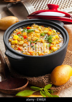 Delicious lentil and vegetable stew in a rustic kitchen in an open crock, high angle view Stock Photo