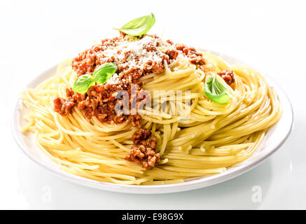 Italian spaghetti Bolognaise topped with a savory tomato based beef sauce with grated parmesan cheese and fresh basil for a healthy Mediterranean diet Stock Photo