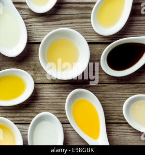 Sauce dish and several soup spoon on wooden surface Stock Photo