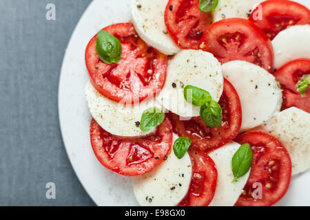 Colorful red and white Italian Caprese salad viewed from above with alternating slices of ripe red tomato and mozzarella cheese Stock Photo