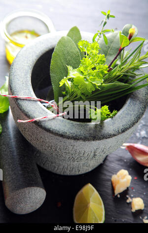 Macro Herbs on Stone Mortar and Pestle, Isolated on Wooden Background. Stock Photo