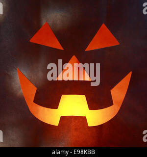 Close Up of Glowing Jack o Lantern Face Cut into Paper Bag Stock Photo