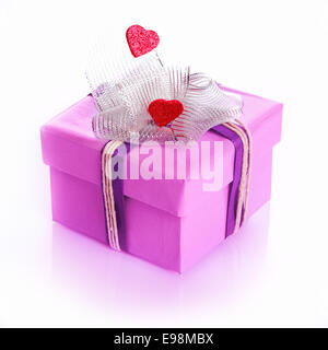 purple gift box decorated with hearts and a ribbon or bow isolated on white Stock Photo