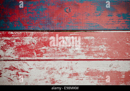 Grunge painted wooden texture background with red paint peeling off weathered timber planks with woodgrain Stock Photo