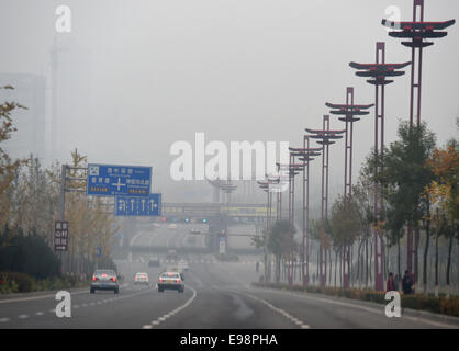 Taiyuan, China's Shanxi Province. 22nd Oct, 2014. Vehicles run on a road amid heavy haze and smog in Taiyuan, capital of north China's Shanxi Province, Oct. 22, 2014. The lingering smog has shrouded the city since Oct. 19. Credit:  Yan Yan/Xinhua/Alamy Live News Stock Photo