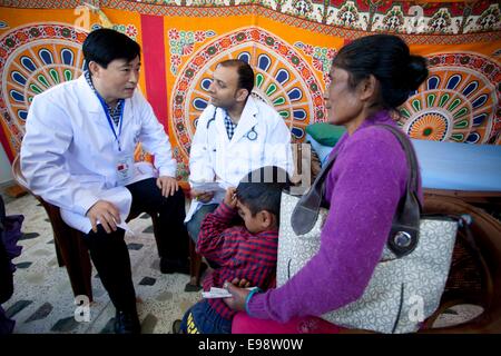 Kathmandu, Nepal. 22nd Oct, 2014. An expert from China (L) checks up a patient during the China-Nepal Friendly Health Camp at Manmohan Memorial Community Hospital in Kathmandu, Nepal, Oct. 22, 2014. The program was jointly organized by the China NGO Network for International Exchanges, Nepal's Araniko society and the hospital with support from the China Foundation for Peace and Development. Credit:  Pratap Thapa/Xinhua/Alamy Live News Stock Photo