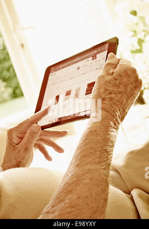 Senior person hands using a tablet computer. Stock Photo