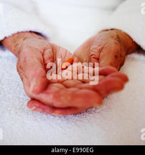 Senior person's hands holding Lipantil fenofibrate cholesterol lowering capsule prescription medication - social care. Stock Photo