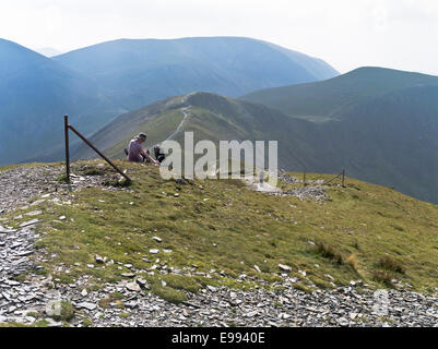 dh Hobcarton crag mountain uk GRISEDALE PIKE LAKE DISTRICT Woman with dog drinking water path one walking cumbria fells hill girl lakeland walker Stock Photo